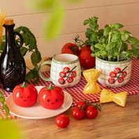 Set aus zwei Salz- und Pfefferstreuern in Tomatenform. Die Keramikstreuer in glänzendem Rot sind ca. 7×7,5 cm groß und tragen ein freundliches, aufgedrucktes Gesicht. Sie sind eine niedliche und dekorative Ergänzung für den Tisch - auf weißem Teller zwisch