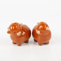 Niedliches Set aus zwei Salz- und Pfefferstreuern in Highland Cow-Form. Die Keramikstreuer in glänzendem Braun sind ca. 7×7,5 cm groß. Die Figuren tragen ein friedliches, aufgedrucktes Gesicht und sind eine niedliche Dekoration für den Tisch - Vollansicht