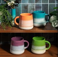 Handbemalte Keramiktasse der Serie Mojave von Sass & Belle. Die bauchige Tasse mit Henkel hat eine glänzende, gesprenkelte Glasur in Lila, die nach unten in Weiß übergeht. Sie ist eine dekorative und trendige Ergänzung für die Küche - mit weiteren Farben d