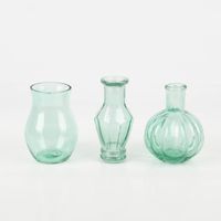 92762-Vasen-3er-Set-aus-recyceltem-Glas-transparent-tuerkis-ca-8x10cm-von-Sass-und-Belle-IMG-9869.jpg Dekoratives Vasen-Set von Sass & Belle aus recyceltem, transparentem, leicht türkisem Glas. Das Set enthält drei unterschiedliche Flaschenformen mit Rillen-Details. Die Vasen sind jeweils etwa 8×10 cm groß und eignen sich ideal für kleine Blumenarrangement