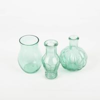 92762-Vasen-3er-Set-aus-recyceltem-Glas-transparent-tuerkis-ca-8x10cm-von-Sass-und-Belle-IMG-9871.jpg Dekoratives Vasen-Set von Sass & Belle aus recyceltem, transparentem, leicht türkisem Glas. Das Set enthält drei unterschiedliche Flaschenformen mit Rillen-Details. Die Vasen sind jeweils etwa 8×10 cm groß und eignen sich ideal für kleine Blumenarrangement