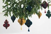 Weihnachtshänger „Honeycomb Topfen“ in Marineblau mit feinem Goldrand, ca. 8 × 12 cm, dekorativer Papieranhänger in Wabenoptik, präsentiert mit goldfarbener Aufhängung zur Veranschaulichung von Form, Farbe und Struktur - an Tannenzweigen praesentiert