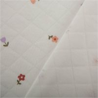 Steppstoff mit feiner Rautenstruktur in Wollweiß und buntem Blümchenmuster – leicht wattiert, weich und ideal für Babydecken, Jacken oder Wohnaccessoires - mit Rueckseite
