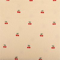Teddystoff Boucle wollweiß mit Kirschen Stickerei. Das Muster zeigt rote Kirschen auf der flauschigen Stoffoberfläche. Breite 145cm - Vollansicht