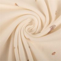 Wollweißer Rippjersey aus Baumwolle, präsentiert mit zarten Motiven von Hase, Rotkehlchen und Schmetterling als weicher Stoff, 1,20 m breit - kunstvoll eingedreht in Falten