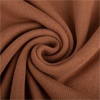 Strickstoff aus 100% Baumwolle in Camel-Braun. Detailansicht der feinen, gleichmäßigen Maschenstruktur. Der Stoff ist 135 cm breit - kunstvoll eingedreht in Falten