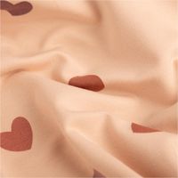 French Terry Sommersweat in Rosa, mit Schlingenstruktur und Herz-Muster. Der Digitaldruck zeigt dunkelrote Herzen auf dem Stoff in 150cm Breite - stilvoll drapiert