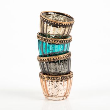 Stimmungsvolle Teelichter aus gerilltem Glas mit einem antik anmutenden Metallrand in den Farben Gold, Türkis, Grau und Rosé. Mit einer Größe von 4,5 x 6 cm zaubern diese Accessoires von Werner Voß glanzvolle Lichtakzente - Vollansicht gestapelt