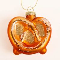 Dekorativer Weihnachtshänger in Form einer glänzenden Brezel in warmem Braun und Goldtönen. Mit einer Größe von 7,5 x 7,5 cm und glitzernden Details ist dieser Anhänger ein besonderer Blickfang für Ihren Tannenbaum - Nahaufnahme