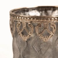 93316-Windlicht-Frosty-Glas-mit-Metallrand-grau-silberfarbig-8-5x11cm-von-Werner-Voss-IMG-3181.jpg Hochwertiges Windlicht aus grauem Glas in frostiger Optik mit einem kunstvoll verzierten, silberfarbenen Metallrand. Mit den Maßen 8,5 x 11 cm sorgt dieses Accessoire von Werner Voß für stimmungsvollen Lichtschein in Ihrem Zuhause - Detailaufnahme