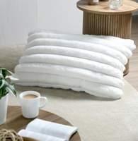 Kuschelkissen 50x80 cm in qwißdekoriert im Wohnzimmer neben Tisch mit Tasse und Buch