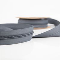 93391-YKK-Reissverschluss-Meterware-Kunststoffspirale-5mm-in-3cm-Breite-individuell-zuschneidbar-Grau-IMG-3584.jpg YKK Reißverschluss Meterware mit 5 mm Kunststoffspirale in Grau, präsentiert als 3 cm breites, flexibel zuschneidbares Band für individuelle Verschlusslösungen - aufgerollt praesentiert