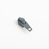 93396-YKK-Schieber-Zipper-fuer-Reissverschluss-Meterware-Kunststoffspirale-5mm-in-3cm-Breite-Grau-1-Stk-IMG-3588.jpg YKK Schieber für Reißverschluss-Meterware mit 5-mm-Kunststoffspirale in Grau, präsentiert als einzelner Zipper passend zur 3 cm breiten Bandware - Nahaufnahme