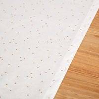 Detailaufnahme eines weißen Tischläufers aus Baumwoll-Canvas mit goldenen Punkten.