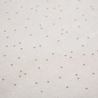 Nahaufnahme des weißen Canvas-Stoffs mit feinen goldenen Punkten.