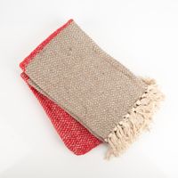 Diese gemütliche Kuscheldecke besticht durch ein klassisches Fischgrät-Dessin in den Farben Natur und Rot. Die Decke mit dekorativen Fransen misst 150 x 125 cm und sorgt für wohlige Wärme - nahaufnahme