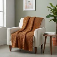 93457-Decke-Plaid-mit-Waffelstruktur-aus-Baumwolle-terracotta-braun-160x130cm-IMG-4142-1.jpg Dieses weiche Plaid aus reiner Baumwolle besticht durch seine markante Waffelstruktur in einem warmen Terracotta-Braun. Mit den Maßen 160 x 130 cm ist die Decke ideal für gemütliche Stunden. - auf einem Sessel praesentiert