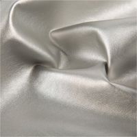 Hochwertiges Kunstleder in elegantem, glänzendem Hellsilber-Metallic mit einer authentischen Lederstruktur. Das 1,40 m breite Material mit Viskose-Rückseite ist ideal für Taschen, Polsterarbeiten oder trendige Bekleidung geeignet - stilvoll drapiert