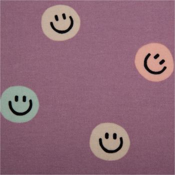 Hochwertiger Baumwoll-Flanell mit fröhlichen Lachgesichtern in Pastelltönen wie Mint und Rosa auf violettem Grund. Der 1,43 m breite, weiche Stoff ist ideal für gemütliche Pyjamas oder Kinderbekleidung - Nahaufnahme