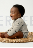 93496-Rippjersey-Rib-Jersey-Stoff-Bio-Baumwolle-Blitze-natur-gruen-1-2m-Breite-Screenshot-2025-12-21-222900.png Baby trägt Body Babykleidung aus Rippjersey mit Blitze-Motiv