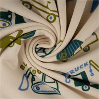 Hochwertiger Soft Sweat aus Baumwolle mit coolen Baufahrzeugen wie Baggern und Kränen in Blau- und Grüntönen auf ecrufarbenem Grund. Der 1,48 m breite Stoff ist ideal für gemütliche Kinderkleidung - kunstvoll eingedreht in Falten