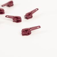 93608-YKK-Schieber-fuer-Reissverschluss-Meterware-Kunststoffspirale-5mm-in-3cm-Breite-Dunkelrot-1-Stk-IMG-5671.jpg Einzelner YKK Schieber für Reißverschluss Meterware 5 mm Kunststoffspirale in Dunkelrot, Detailansicht schräg fotografiert