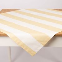 Tischdecke aus Baumwolle mit Streifen in Vanille und Ecru von SCHÖNER LEBEN, diagonal über den Tisch gelegt.