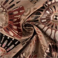 Der hochwertige Jacquard Stoff Premium Dekostoff Mandala Circle Sun taupe rot schwarz 1,4m Breite besticht durch sein detailreiches Mandala-Design für ausdrucksstarke, langlebige und stilvolle Nähprojekte - kunstvoll eingedreht in Falten