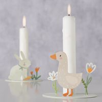 94065-Kerzenhalter-Hase-und-Gans-20-Stk-3-lagig-33x33cm-FSC-Papier-von-Boltze-2079904-Ambientebild.jpg Dekorierte Kerzenhalter mit Gans und Hase auf einem Tisch mit brennenden weißen Kerzen