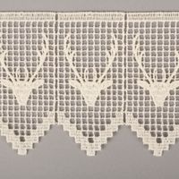Detail der naturfarbenen Häkelborte mit filigranem Hirschmotiv und feiner Spitzenstruktur.