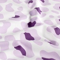 Nahaufnahme von weichem Baumwolljersey mit Leo-Muster in Weiß, Lila und Violett in sanften Stofffalten.
