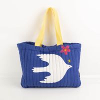 Geräumige Strandtasche (44x33x10 cm) in Blau mit weißem Vogel-Motiv und gelben Tragegriffen. Das gesteppte Design bietet Stabilität und reichlich Platz für Ihre Utensilien – ideal für Strand, Pool oder Einkauf - Vollansicht
