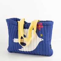 Geräumige Strandtasche (44x33x10 cm) in Blau mit weißem Vogel-Motiv und gelben Tragegriffen. Das gesteppte Design bietet Stabilität und reichlich Platz für Ihre Utensilien – ideal für Strand, Pool oder Einkauf - Nahaufnahme