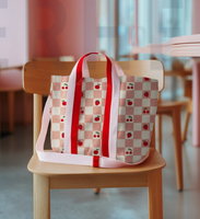 Genähte Tasche aus beschichtetem Canvas Stoff mit Obstmotiv auf Stuhl platziert