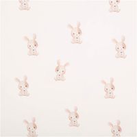 Bio Jersey Baumwollstoff, 1,50 m breit – wollweißer Grund mit locker verteilten, aquarellartig illustrierten Kaninchen in Beige-Rosa, jedes mit kleiner Blume, zart und sanft, ideal für Babymode - Vollansicht