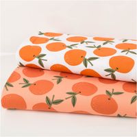 Canvas-Baumwollstoff, 138 cm breit, in hellem Peach-Orange mit großflächigen, locker verteilten Orangen in sattem Orange mit olivgrünen Blättern – frisch, fruchtig und sommerlich-mediterran - in Szene gesetzt