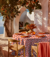 Abwaschbarer Tischdeckenstoff, beschichtet, 1,48 m breit – rosa-weißes Streifenmuster mit locker verteilten großen Orangen mit grünen Blättern, fröhlich, frisch und sommerlich-mediterran - in mediterraner Tischszenerie praesentiert