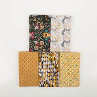 Fünf Baumwollstoffe im Patchwork Set Fiesta mit geometrischen Designs, Totenkopfmotiv und Retro-Mustern.