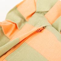 Kissen Summer Stripes mit Rüschenrand Nahaufnahme eines Stoffes mit orangefarbenen und hellgrünen Streifen und einem orangen Reißverschluss