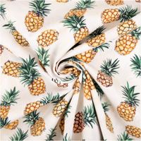 Baumwollpopeline mit fotorealistischen Ananas in sattem Gelb-Orange mit grünen Blätterkronen auf ecruem Grund – tropisch, frisch und sommerlich. Breite: 1,40 m. Ideal für Näh- und Sommerprojekte - kunstvoll eingedreht in Falten