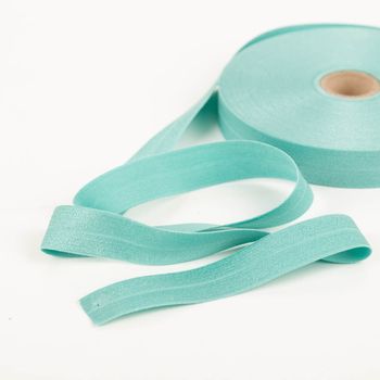 YKK elastisches Falzband / Falzgummi 20mm mint (20-m-Box) Mint-farbenes Band aufgerollt und teils entrollt, zeigt glatte Textur und gleichmäßige Kanten.