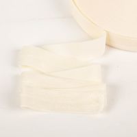 YKK elastisches Falzband / Falzgummi 20mm rohweiß (20-m-Box) Nahaufnahme eines cremefarbenen Schraegbands, aufgerollt und leicht entfaltet.