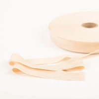 YKK elastisches Falzband / Falzgummi 20mm haut (20-m-Box) Beiger Stoffstreifen auf Rolle, glatt und weich, liegend auf hellem Untergrund.