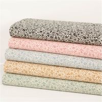 Baumwollstoff Popeline Stoff Allover Blätterranken Serie Romantic Garden Schwarz 1,40m Breite Ein Stapel dekorativer Stoffe in verschiedenen Farben mit floralen Mustern auf weissem Hintergrund.