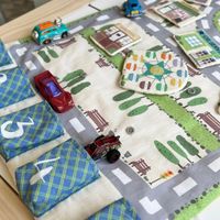 Detailansicht der Spielmatte My Town mit gedruckten Straßen, Gebäuden und Parkplätzen Detailansicht der Spielmatte My Town mit gedruckten Straßen, Gebäuden und Parkplätzen