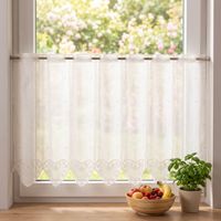 Romantische Scheibengardine mit Herzmuster am Fenster, helles Licht strömt ins Zimmer, mit Obstschale.