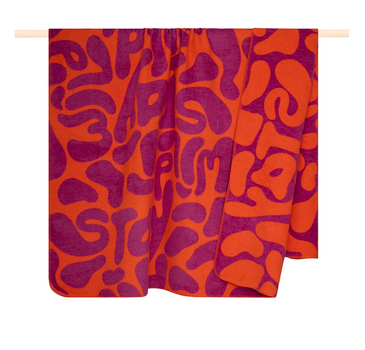 PAD Kuscheldecke Wild Pumpkin-Fuchsia in XL 150 × 200 cm mit modernem Jacquard-Muster in Orange und Fuchsia, über Stange drapiert