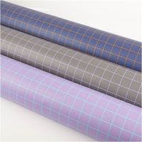 Kunstleder Happy Collection Karos dunkelgrau flieder von Cherry Picking by Swafing Drei Stoffrollen mit kariertem Muster in Blau, Grau und Lila zeigen unterschiedliche Farbtöne.