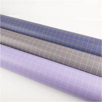 Kunstleder Happy Collection Karos dunkelgrau flieder von Cherry Picking by Swafing Drei Stoffrollen in Blau, Grau und Lila mit geometrischem Muster auf weisser Unterlage.