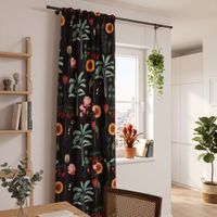 Vorhang mit tropischem Blumenmuster in intensiven Farben, haengend vor Fenster im Wohnzimmer.